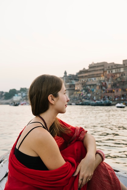 Free photo western woman on a boat exploring the river ganges