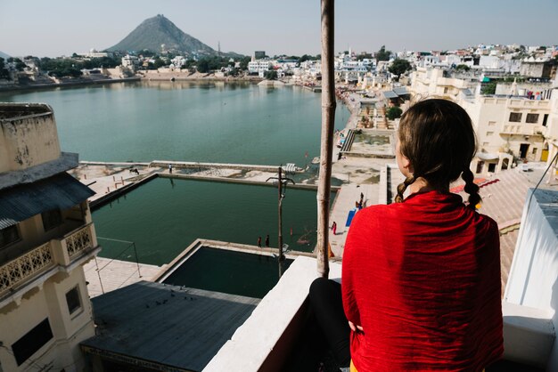 Западная женщина наслаждается видом на озеро Пушкар в Раджастхане