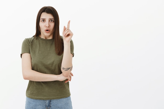 What if we do this. Portrait of nervous and intense concerned woman sharing point of view thinking up new idea raising finger in eureka gesture