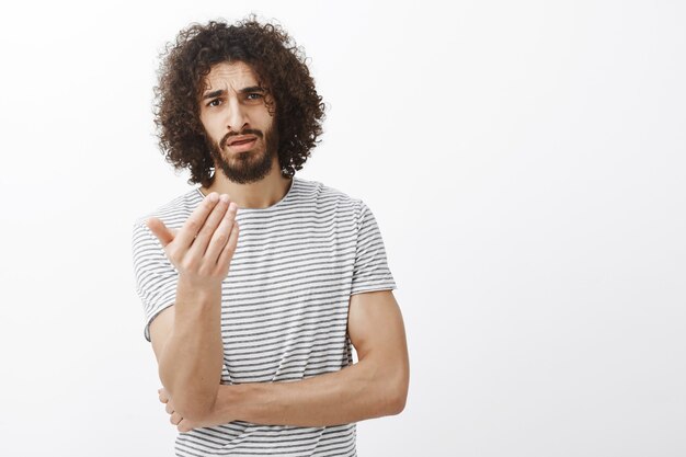 What is your point man. Displeased freaking out boyfriend with beard and afro haircut, shaking palm