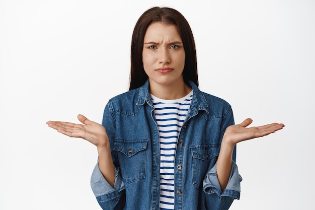 What problem. Confused frowning woman shrugging shoulders, cant understand whats big deal, why so serious, standing puzzled against white background