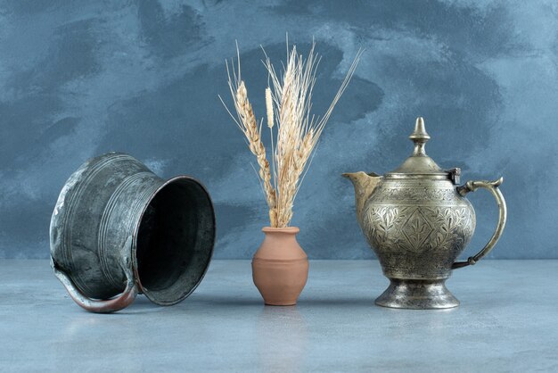 Wheat plant with ethnic metallic pot and kettle around. High quality photo