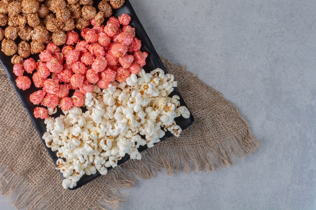 Wheat and rice piled on a wooden board on marble.