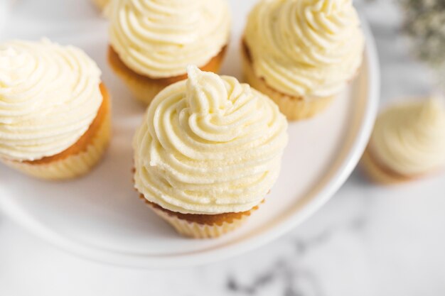 Whipped cream on cupcakes over cake stand