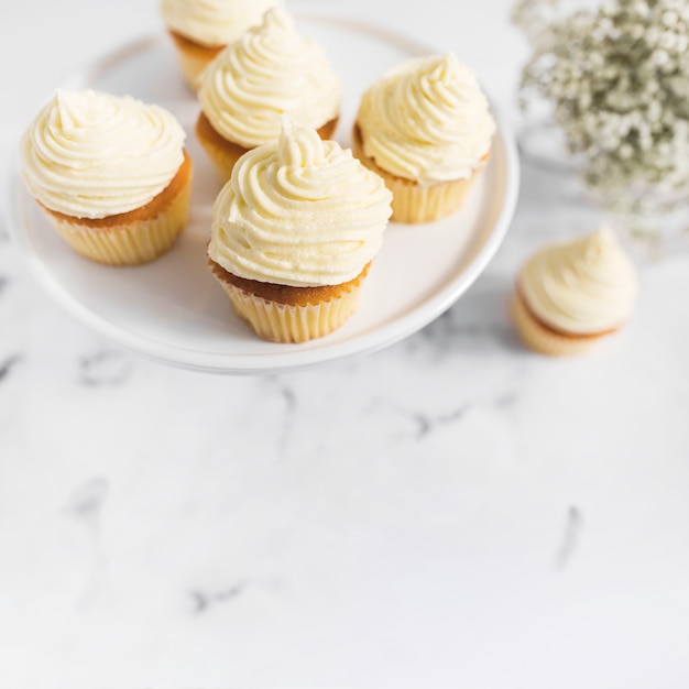 Whipped cream cupcakes on cake stand