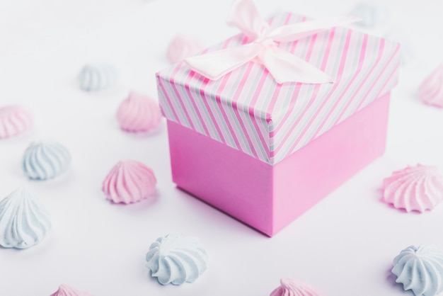 Whipped cream and gift box with ribbon on white background