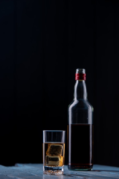 whisky glass and bottle on wooden table