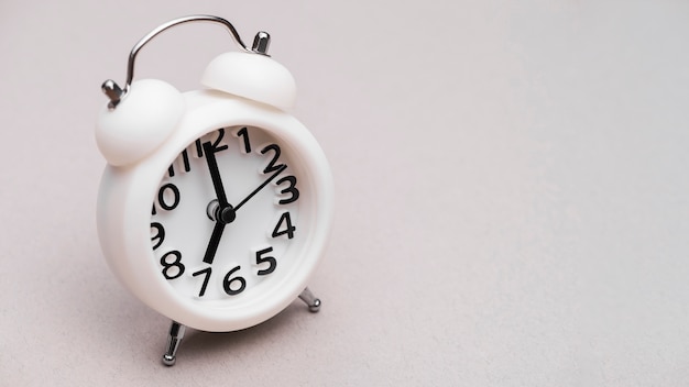 White alarm clock on colored background