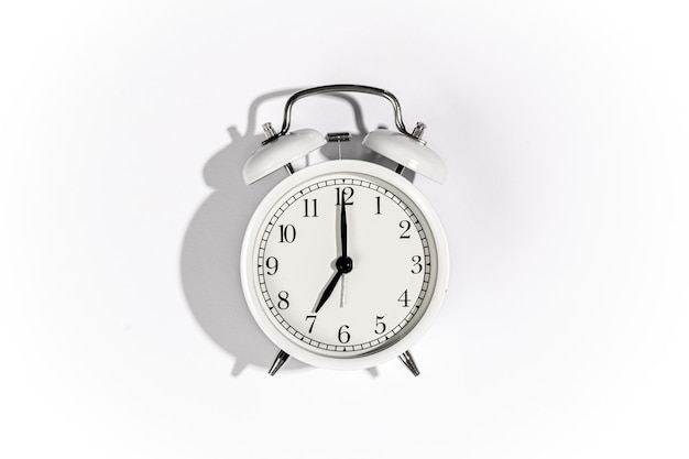 White alarm clock on a white background top view