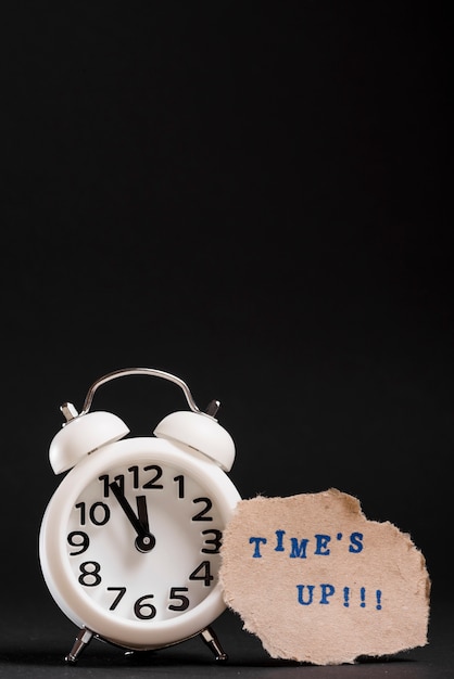 Free photo white alarm clock with time's up text on black background