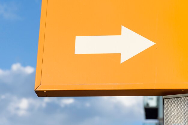 white arrow on orange background