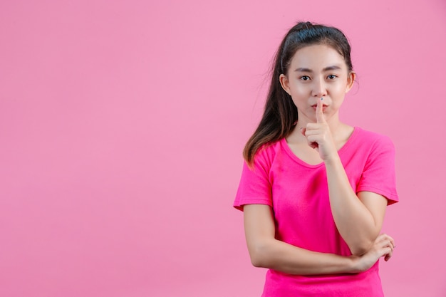 White Asian women wear pink shirts. Poses to not make noise On the pink .