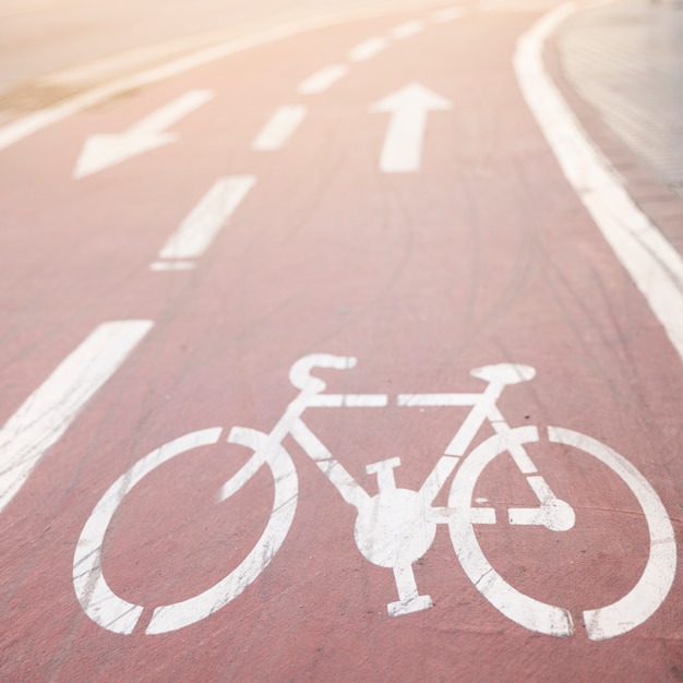 White asphalt bike lane with directional sign