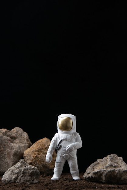 暗いSFファンタジーの岩と月の白い宇宙飛行士