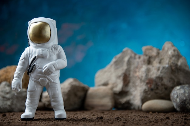 White astronaut with rocks on moon blue surface fantasy cosmic sci fi