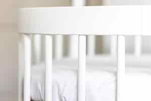 Free photo white baby bed close up waiting for a baby