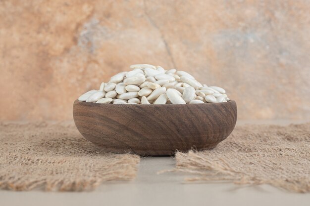 White beans in a cup or bowl on concrete.