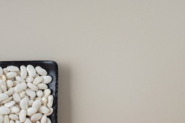 White beans in food trays on concrete.