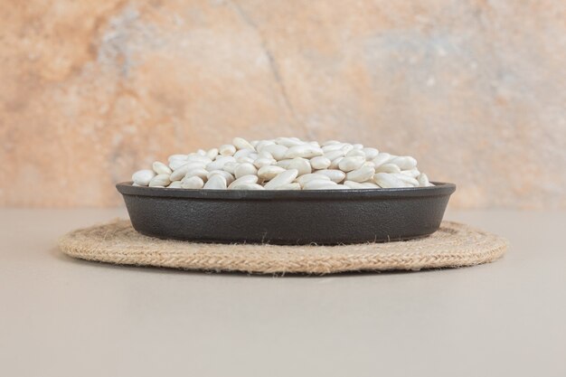 White beans in food trays on concrete.