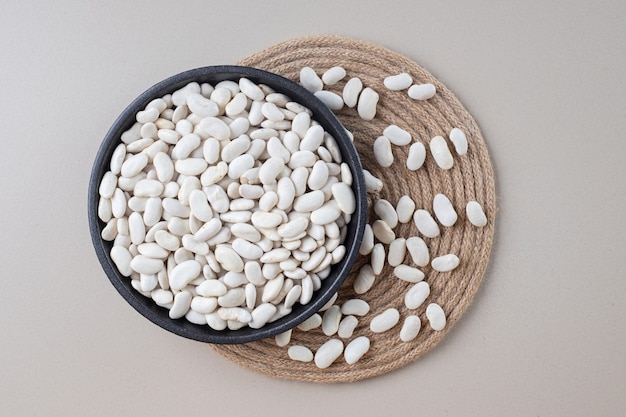 Free photo white beans inside a bowl on concrete.