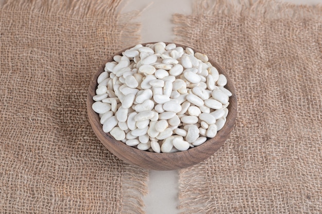 White beans inside a bowl on concrete.