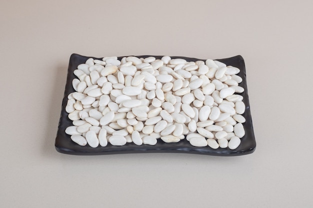 Free photo white beans on a piece of board on concrete.