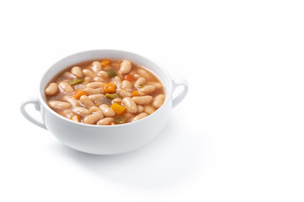 White beans soup with vegetables in white bowl on wooden table