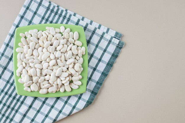 White beans on a square platter on the concrete.