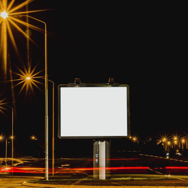 White billboard with traffic lights at night