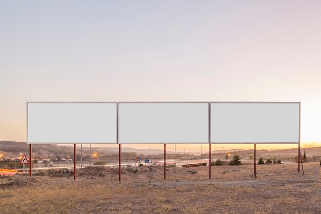 White billboards for advertisement near the highway during sunset