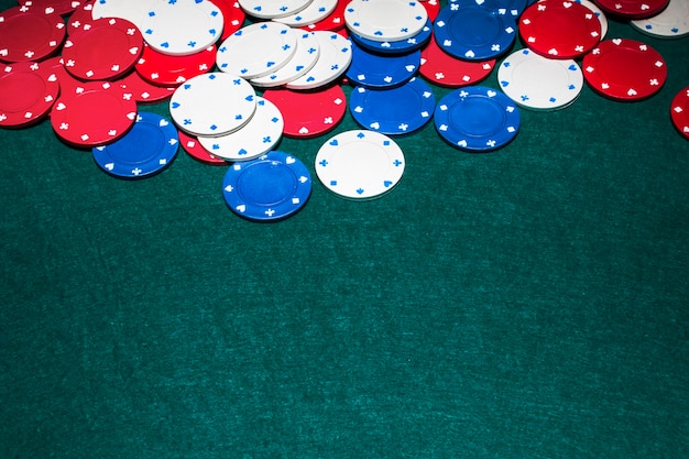 White; blue and red casino chips on green background