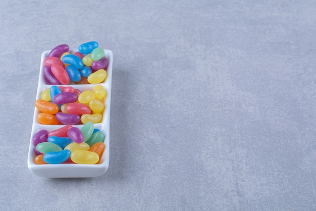 灰色の表面にカラフルな豆菓子でいっぱいのホワイトボード