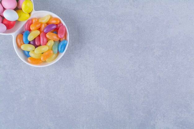 A white board full of colorful bean candies on gray surface