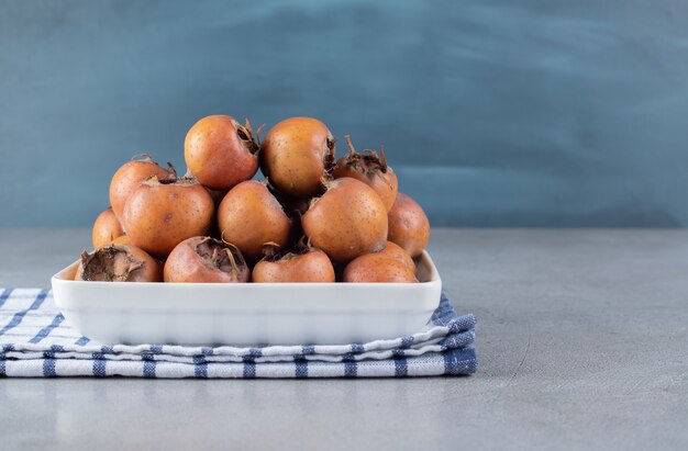 A white board with ripe persimmons on a tablecloth. High quality photo
