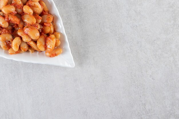 White bowl of boiled soy beans placed on stone surface