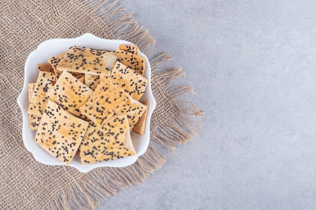 white bowl of crispy delicious crackers on stone table