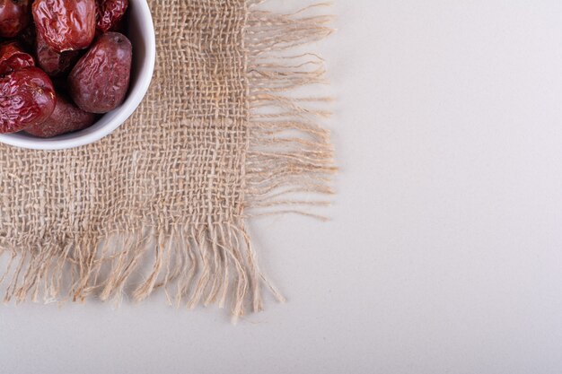 White bowl of dried tasty silverberry fruits on white background. High quality photo