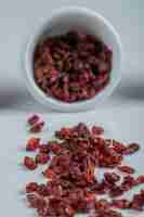 Free photo a white bowl full of dried cranberries .