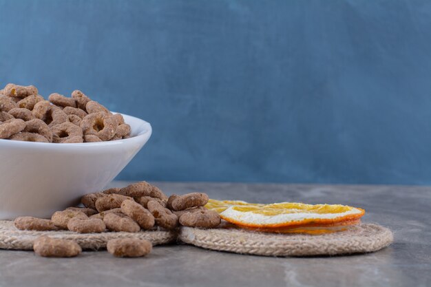 A white bowl of healthy chocolate cereal rings for breakfast