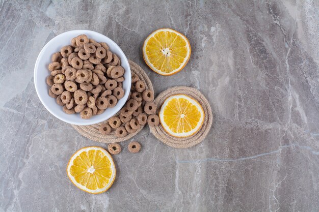 A white bowl of healthy chocolate cereal rings for breakfast .