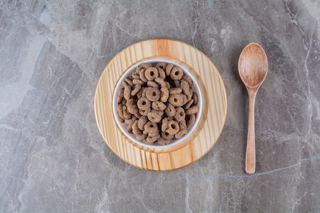 A white bowl of healthy chocolate cereal rings for breakfast