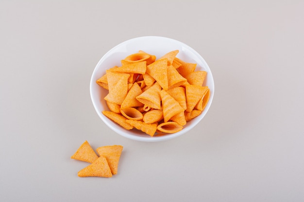 White bowl of triangle chips on marble background. High quality photo