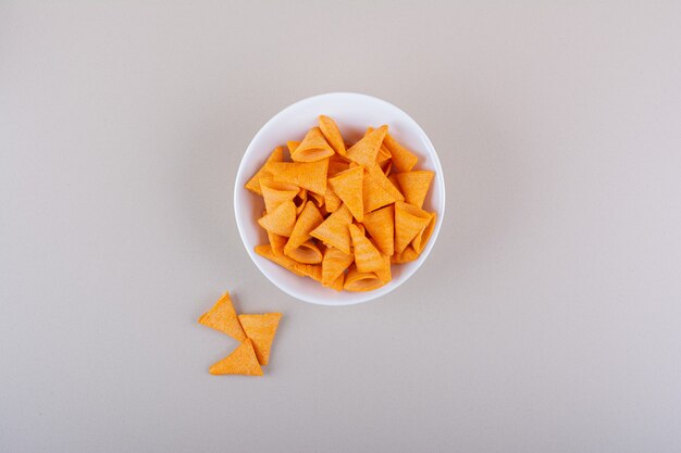 White bowl of triangle chips on marble background. High quality photo