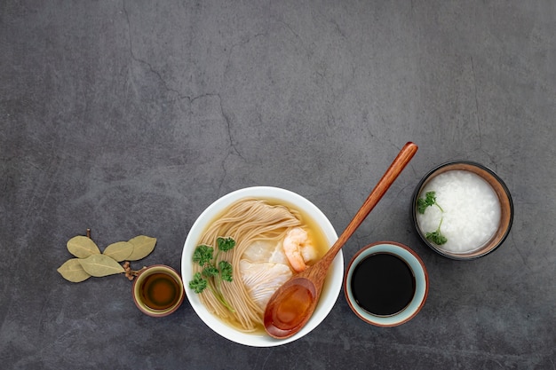 灰色の背景に麺スープと白いボウル