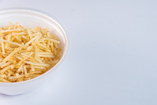 White bowl with potato straw on white background