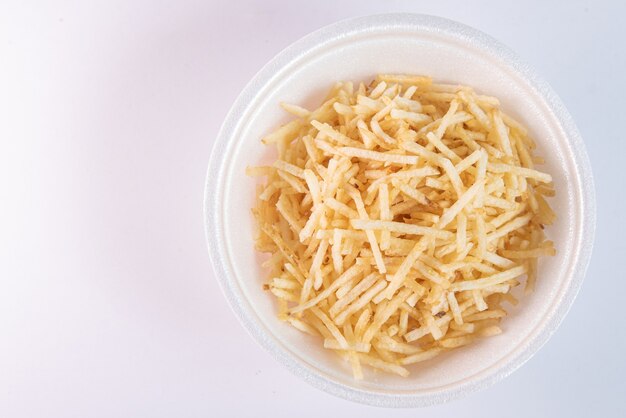 White bowl with potato straw on white background