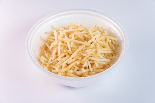 White bowl with potato straw on white background