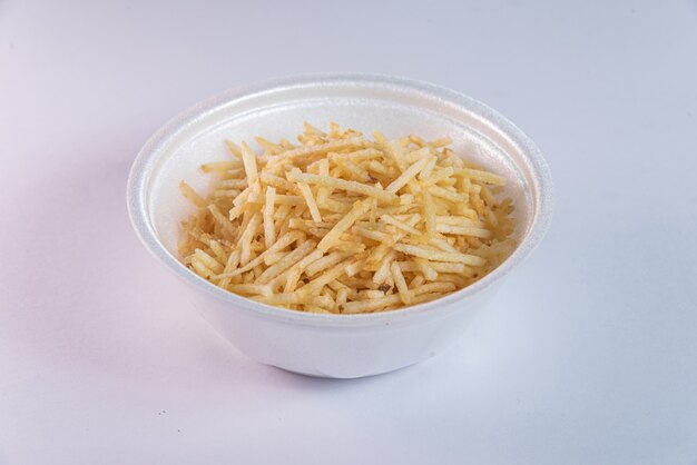 White bowl with potato straw on white background