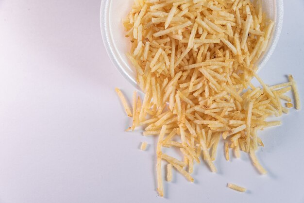 White bowl with potato straw on white background