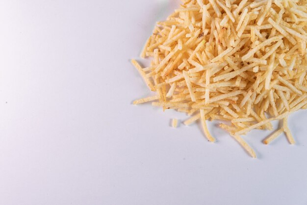 White bowl with potato straw on white background